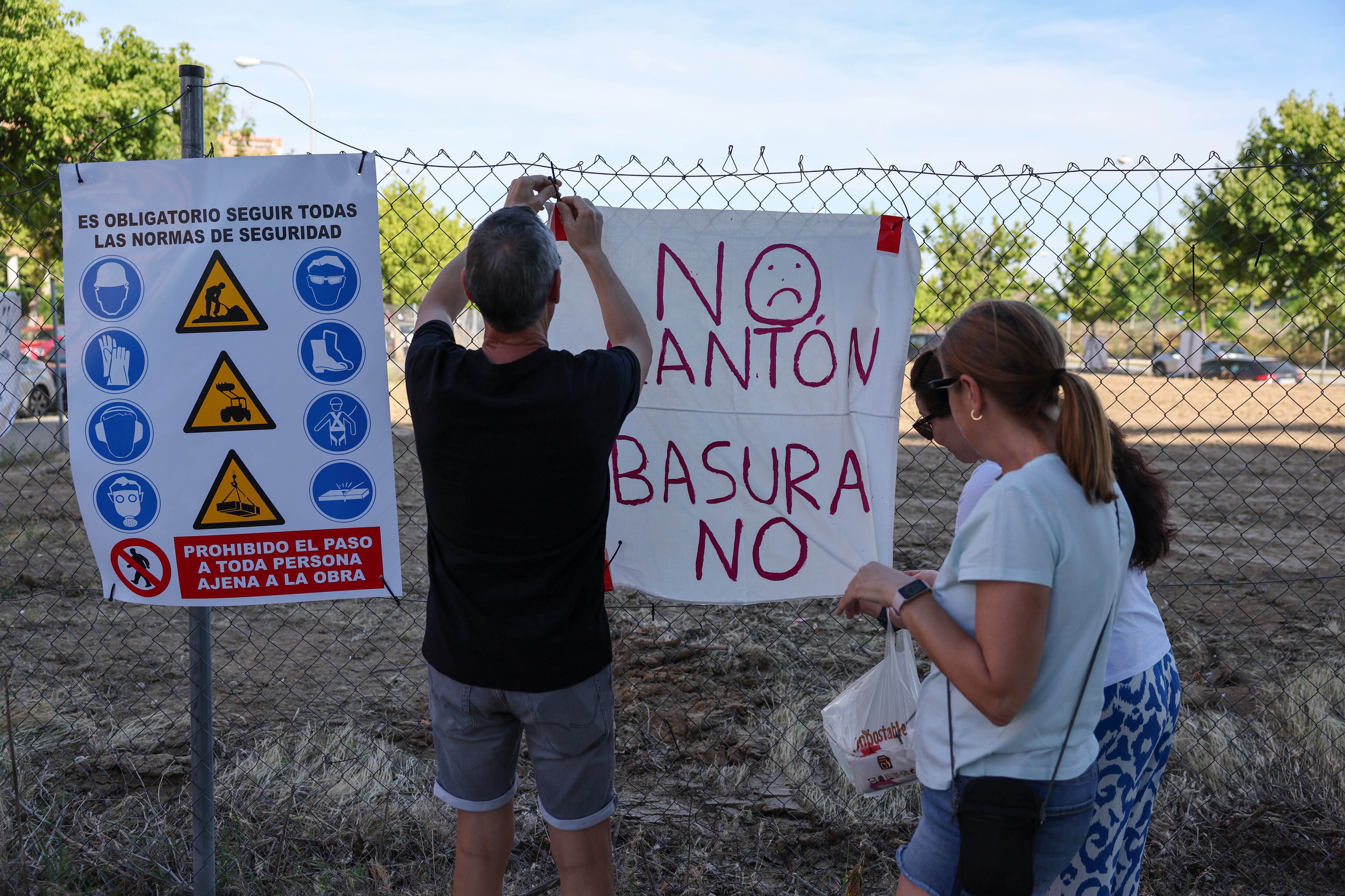 Tres vecinos de Carabanchel colocan un cartel en la parcela donde no saben qué orevé construir el Ayuntamiento.