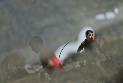 Muchachos palestinos inspeccionan lo que la policía palestina dice que son los restos de un ataque aéreo israelí en el norte de la Franja de Gaza.