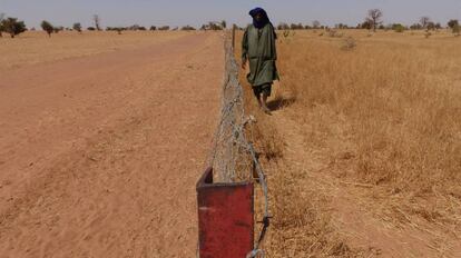 Demba Sow, tras la valla que separa la zona de plantación de forraje contra la desertificación, en Mbar Toubab, Senegal.