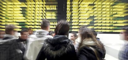 Varias personas junto al panel informativo del aeropuerto de Manises, Valencia