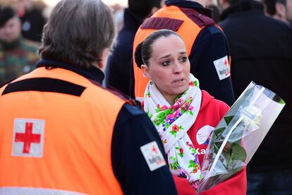 Una mujer con un ramo de flores durante el acto de homenaje celebrado en el aeropuerto de Bruselas.