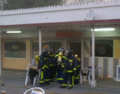 Un grupo de bomberos, en el local donde se ha producido el fuego.