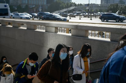Un grupo de personas sale de un paso subterráneo en Pekín.