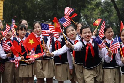Niños vietnamitas ondean banderas ante la llegada del presidente de los EE UU Donald Trump.
