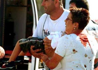 Voluntarios evacúan a un niño herido en el atentado.