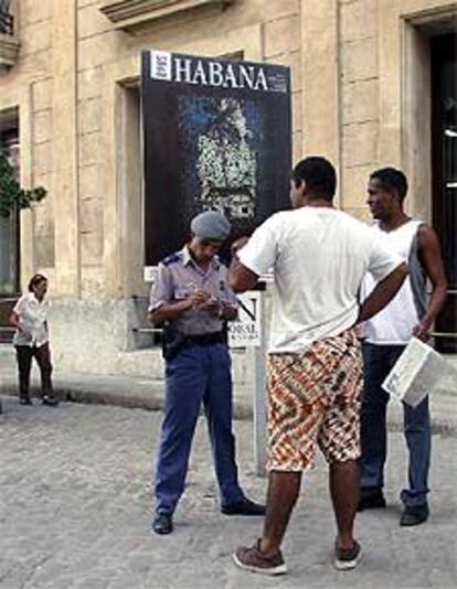 Un policía identifica a dos cubanos en una calle de La Habana a principios de año.