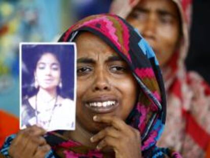 Una mujer muestra el retrato de una familiar víctima del derrumbe durante una oración especial por las víctimas del derrumbe del edificio Rana Plaza, cuando se cumple un año de la tragedia en Savar, Dacca (Bangladesh).