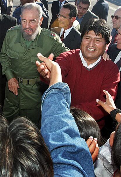 Fidel Castro y Evo Morales saludan a unos estudiantes en el aeropuerto internacional de La Habana.