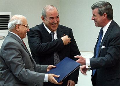 Paul Bremer (a la derecha), entrega documentos al ministro de Justicia, junto al primer ministro iraquí (en el centro).