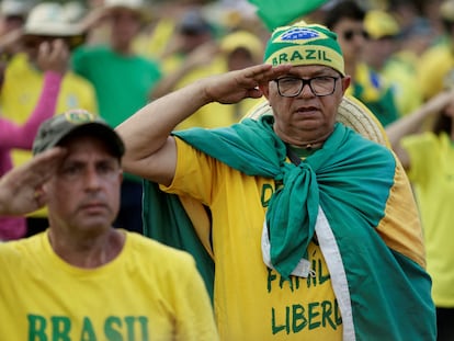 Manifestantes bolsonaristas hacen un saludo militar, este jueves en una protesta golpista ante el cuartel general del Ejército en Brasilia, este jueves.