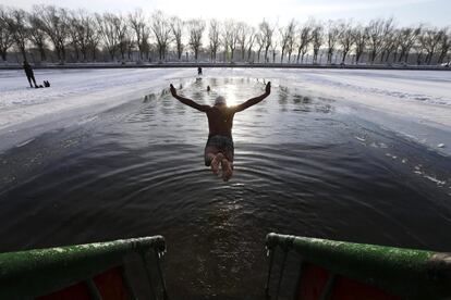 Un miembro del equipo de natacin de invierno, Shenyang Beiling, se tira a las aguas heladas de un lago a 20 grados bajo cero en el parque de Beiling, en Shenyang, provincia de Liaoning (China).