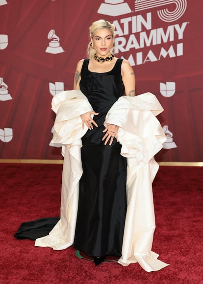 La productora y cantante Elena Rose, con vestido negro y gran capa blanca.