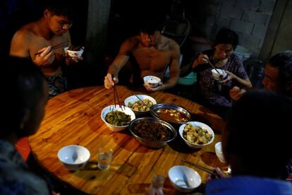 Worker Shi Shenwei (2nd L) and his colleagues and family members eat dinner in the yard of an old farm house in the village of Huangshan, near Quanzhou, Fujian Province, China, September 28, 2016. REUTERS/Thomas Peter           SEARCH "BRICK CARRIER" FOR THIS STORY. SEARCH "WIDER IMAGE" FOR ALL STORIES. 