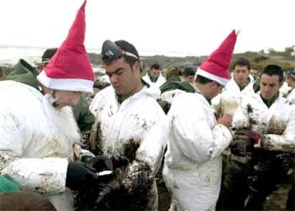 Soldados tocados como Papá Noel ayudan a limpiarse a sus compañeros en la playa de Lira.