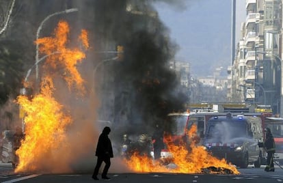 Firemen extinguish a fire after clashes between students and policemen in Barcelona.