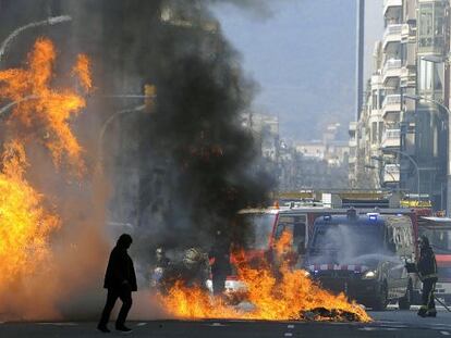 Firemen extinguish a fire after clashes between students and policemen in Barcelona. 