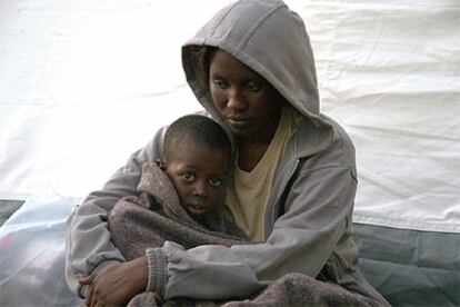 Una mujer y su hijo, rescatados de la embarcación en la que fueron localizados dos fallecidos, descansan en un campamento de la Cruz Roja.