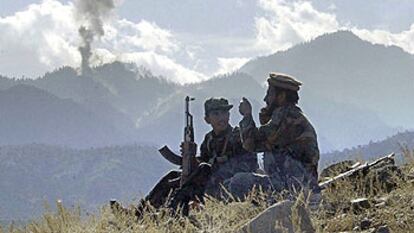 Dos <b><i>muyahidin</b></i> charlan mientras observan el humo de las bombas lanzadas contra Tora Bora, en la pasada guerra afgana.