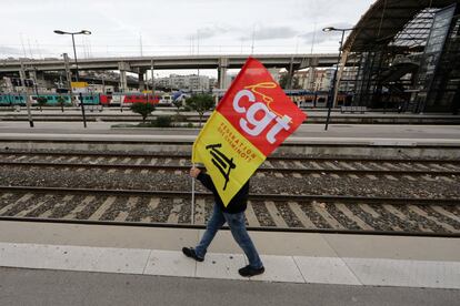 Hay 245 manifestaciones o concentraciones convocadas en todo el país. La de París debe empezar a primera hora de la tarde en la Estación del Norte y terminará en la plaza de la Nación. En la imagen se ve a un trabajador ferroviario francés de SNCF en huelga sostiene una bandera del sindicato CGT mientras camina sobre una plataforma en la estación de trenes de Niza (Francia), este jueves.