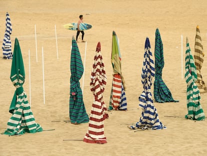 Un surfista camina por la playa de San Lorenzo, el pasado martes en Gijón.