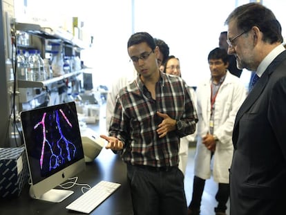 Mariano Rajoy escucha a un investigador durante una visita al Centro Nacional de Investigaciones Cardiovasculares.