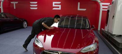 Un empleado de Tesla limpia un Modelo S en una tienda de la compa&ntilde;&iacute;a en Pek&iacute;n (China).