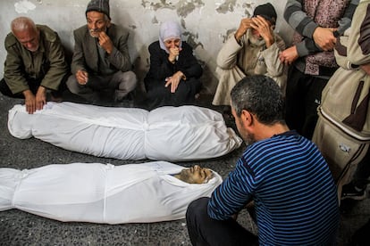 Varias personas lloran alrededor de los cadáveres de dos víctimas de ataques israelíes, el martes en Ciudad de Gaza.