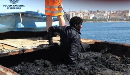 Un inmigrante sale de entre los residuos de un contenedor transportado en un barco que hace la línea Ceuta-Algeciras.