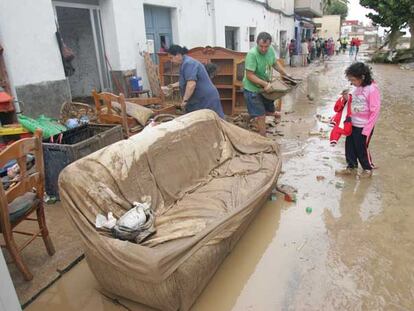 Vecinos de El Verger (Alicante) sacan los muebles de su casa, inundada por la crecida del río Girona.