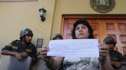 Una cliente de Air Comet muestra su billete de regreso a España frente al Consulado de Lima.