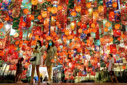 Dos mujeres atraviesan un centro comercial de Bangkok decorado con farolillos de colores por la llegada del Año Nuevo Chino.