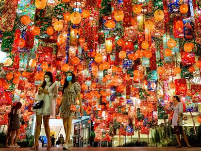 Dos mujeres atraviesan un centro comercial de Bangkok decorado con farolillos de colores por la llegada del Año Nuevo Chino.