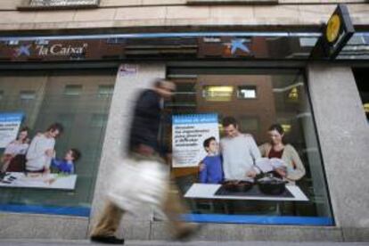 Un hombre pasa delante de una oficina de La Caixa en Madrid. El sistema bancario se encuentra entre los más fuertes de Europa, según William Murray, portavoz adjunto del FMI. EFE/Archivo