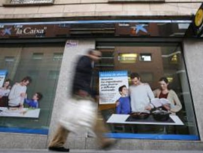 Un hombre pasa delante de una oficina de La Caixa en Madrid. El sistema bancario se encuentra entre los más fuertes de Europa, según William Murray, portavoz adjunto del FMI. EFE/Archivo