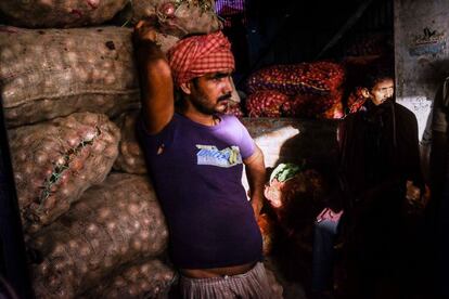 Un cargador de sacos de verduras en un mercado local en el sur de Nueva Delhi, India.