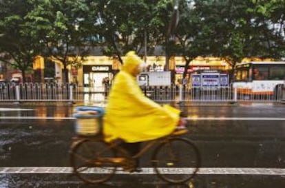 Un ciclista bajo la lluvia en la ciudad china de Huangzhou.