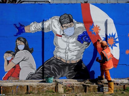 Homem pinta muro com campanha de combate à covid-19 em Jacarta, em 27 de agosto.