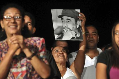 Una mujer levanta una fotografía de Fidel Castro durante la celebración de la víspera de su 85 cumpleaños, anoche en el teatro Karl Marx de La Habana