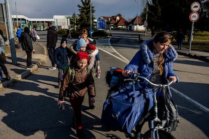 Un grupo de personas camina con sus pertenencias en el cruce fronterizo de Tiszabecs-Tiszaujlak. Ya se han formado largas colas en los cruces fronterizos húngaro-ucranianos después de que Rusia comenzara un ataque a gran escala contra Ucrania en las primeras horas del 24 de febrero.