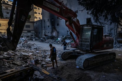 Mohammad Shbibi (a la derecha) camina entre los escombros de un edificio municipal bombardeado por Israel en Nabatieh, el 17 de octubre de 2024.