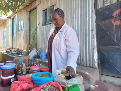 An Ogiek woman, Mrs. Saaya, displays a variety of medicinal herbs at a sales point.