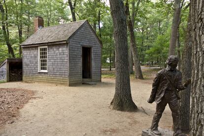 Réplica de la cabaña de Thoreau y estatua del escritor cerca de Walden.