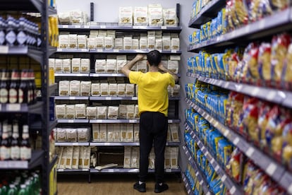 En la imagen, un dependiente ordena un estante con diferentes tipos de pasta en uno de los locales de Market Casa Italia, en Barcelona.