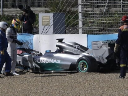 Hamilton observa seu carro após sofrer um acidente.