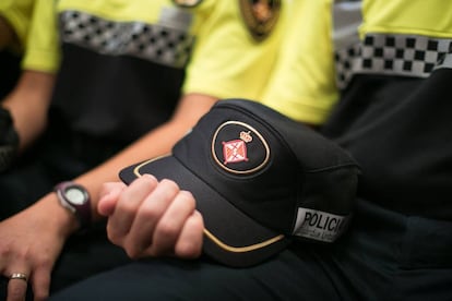 Un agent sosté una gorra de la Guardia Urbana en l'entrega de despatxos de la 87a promoció.