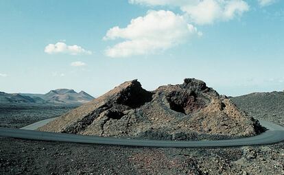 Carretera rodeando un cráter volcánico, en el Parque Nacional de Timanfaya, en la isla de Lanzarote, provincia de las Palmas de Gran Canaria (Canarias).