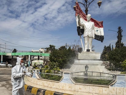 Un trabajador desinfecta una estatua del expresidente sirio Hafez el Asad, en la ciudad de Qamishli, en el nordeste de Siria, el pasado martes.