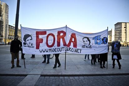 Los manifestantes sostienen una bandera donde se lee "Fuera", como protesta contra las medidas de austeridad del gobierno y exigir la dimisión del Primer Ministro de Portugal fuera del Patio da Gale, en Terreiro do Paco, en Lisboa.