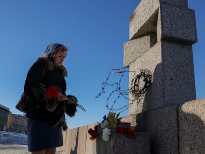 Una mujer depositaba el lunes flores en recuerdo de Alexéi Navalni, en el monumento a las víctimas de la represión política en San Petersburgo.