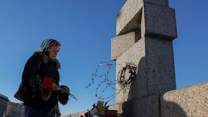 Una mujer depositaba el lunes flores en recuerdo de Alexéi Navalni, en el monumento a las víctimas de la represión política en San Petersburgo.